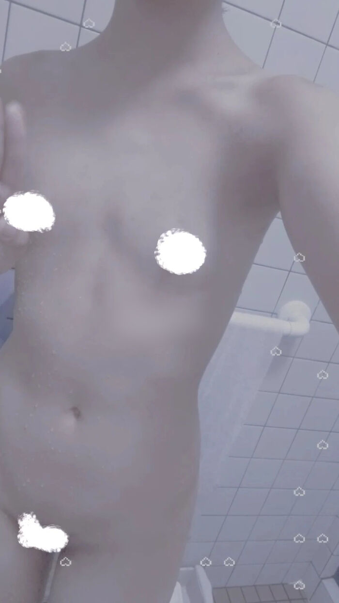 22-year-old female student holding a smartphone with her face and taking a naked hair nude mirror photo 12th image