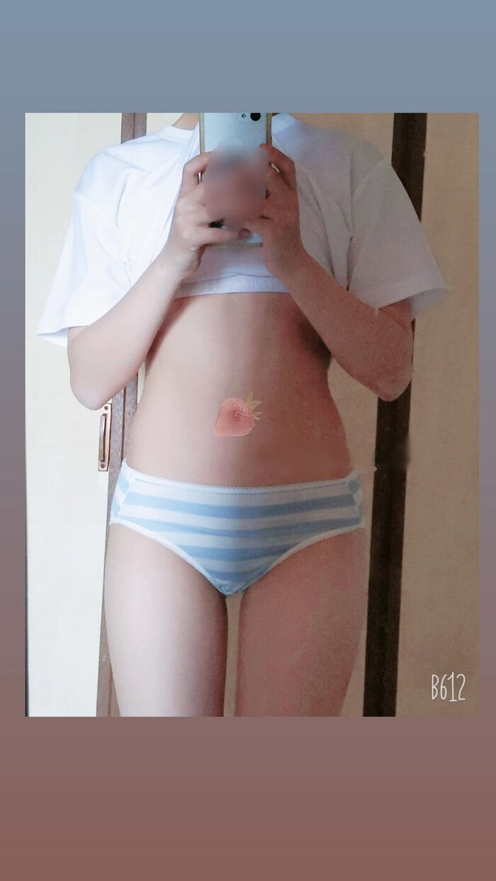 22-year-old female student holding a smartphone with her face and taking a naked hair nude mirror photo 5th image